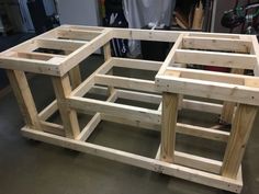 two wooden tables sitting next to each other on top of a hard wood floor in a garage