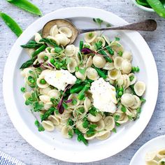 pasta with peas, asparagus and parmesan cheese on a white plate