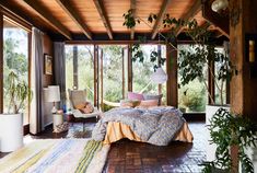 a bedroom with a hammock hanging from the ceiling next to a bed covered in blankets and pillows