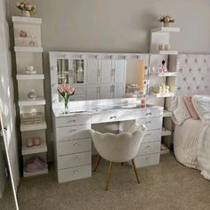 a bedroom with white furniture and pink flowers on the dresser next to it is also a bed