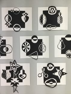 six black and white paper cut outs on a wall