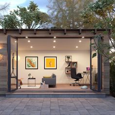 a room with a couch, chair and desk in it next to a tree filled yard