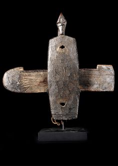 an old wooden object is on display in front of a black background with the image of a plane