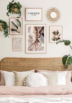 a bed topped with lots of pillows and pictures on the wall