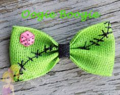 a green bow with a ladybug on the side and black dots in the middle