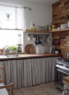 a kitchen with a stove, sink and window