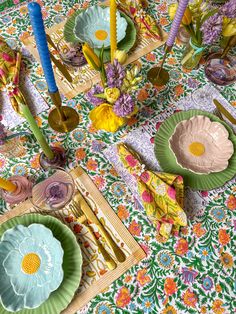 the table is covered with colorful plates and place settings