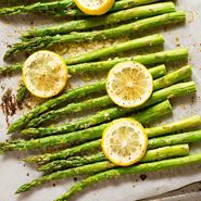 asparagus and lemons on a baking sheet