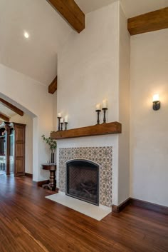 a living room filled with furniture and a fire place in the middle of a wooden floor