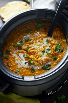 a crock pot filled with soup and garnished with parsley