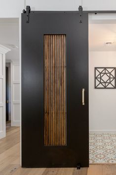 a black door with wooden slats on the front and side panels in an entry way