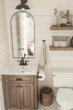 a bathroom with a toilet, sink and mirror in it's centerpieces