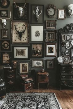 a room filled with lots of framed pictures and deer heads on the wall above it