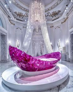 a large purple object sitting on top of a white table next to a chandelier