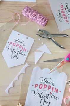 valentine's day gift tags with scissors and spools of twine on the table