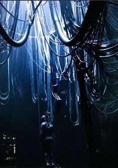 a man standing in the middle of a room filled with wires