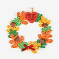 a handmade wreath with an orange and green heart on the front, saying enter with a thanveli heart