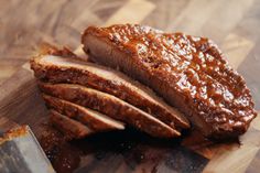 sliced meat sitting on top of a cutting board next to a knife