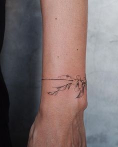 a woman's arm with a small flower tattoo on the left side of her wrist