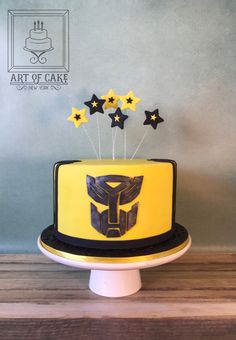 a yellow and black cake with stars on top