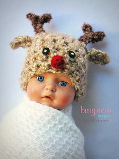 a baby wearing a knitted reindeer hat