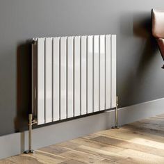 a white radiator sitting on top of a wooden floor next to a wall