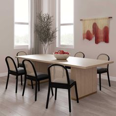 a dining room table with four chairs and a bowl of fruit on it