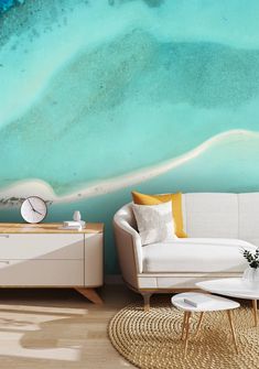 a living room with a white couch and blue ocean wall mural on the wall behind it