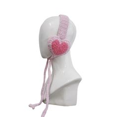 a white mannequin head with a pink knitted heart on it's side