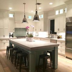 a kitchen island with four stools in front of it