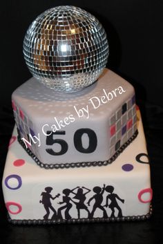 a birthday cake with a disco ball on top and the number 50 written on it