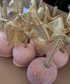 pink and gold candy apples with bows on them