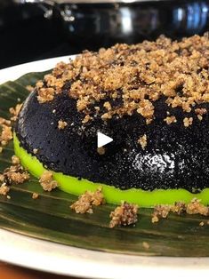 a cake with green frosting and crumbs on it sitting on a plate