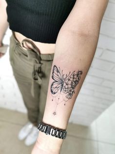 a woman's arm with a butterfly tattoo on the left side of her arm