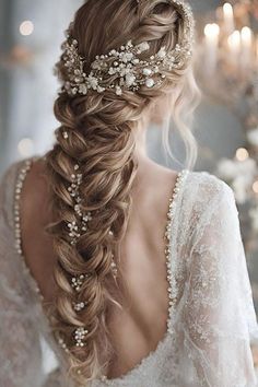 a woman with long hair wearing a braid and pearls in her hair is shown from the back