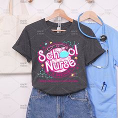 two t - shirts and a stethoscope hang on a rack in front of a white wall