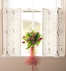 a vase with flowers in it sitting on a window sill next to a window