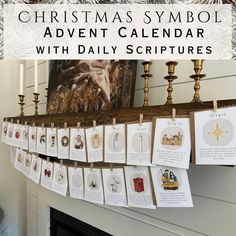 a christmas symbol calendar hanging on a mantle with cards attached to it and candles in the background