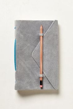 a small notebook with a pencil sticking out of the cover and an eraser on top