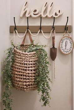 there is a wicker basket hanging on the wall next to a clock and hooks