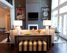 a living room filled with furniture and two lamps on top of it's tables