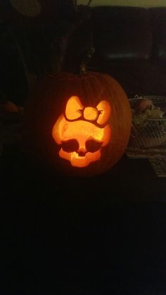 a pumpkin carved to look like a cat with glasses on it's face, sitting in the dark