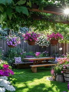 a wooden bench sitting in the middle of a lush green yard filled with lots of flowers