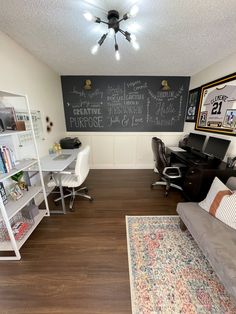 a living room filled with furniture and a chalkboard on the wall above it's desk