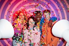 a group of people standing next to each other with confetti on their faces