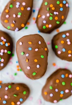 chocolate covered donuts with sprinkles on white paper