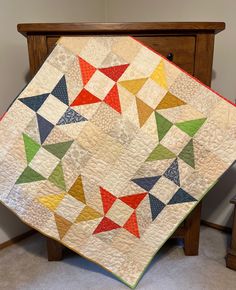 a quilted table topper with colorful triangles on it