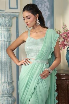 Turquoise green pre-draped saree featuring sheer ruffled frill border. Comes with sequined, zari and resham work  blouse and a waist belt with tiny hanging drops. - Aza Fashions Green Georgette Top For Wedding, Green Fitted Top With Traditional Drape, Green Fitted Tops With Traditional Drape, Fitted Green Top With Traditional Drape, Sleeveless Green Tops For Wedding, Green Sleeveless Wedding Top, Green Ruffled Pre-draped Saree For Reception, Elegant Green Ruffled Pre-draped Saree, Elegant Fitted Pista Green Blouse