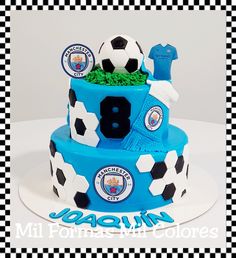 a cake with soccer balls on it is decorated in blue and black