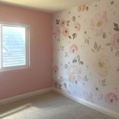 an empty room with flowers painted on the walls and carpeted flooring in front of a window